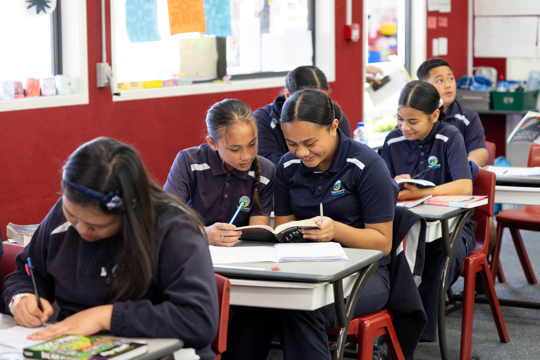 Students smiling and reading personalised learning and extension